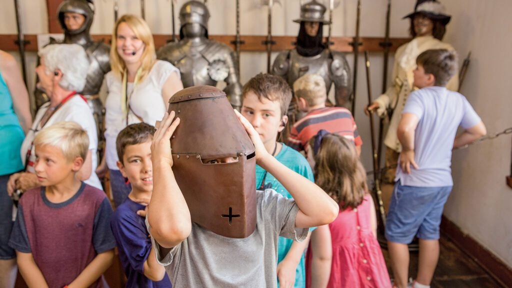 Kids trying on helmet during the Koblenz Knights Excursion on Uniworld Boutique River Cruises