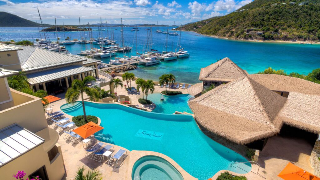 A view of the pool, water, and marina at Scrub Island Resort, Spa, and Marina