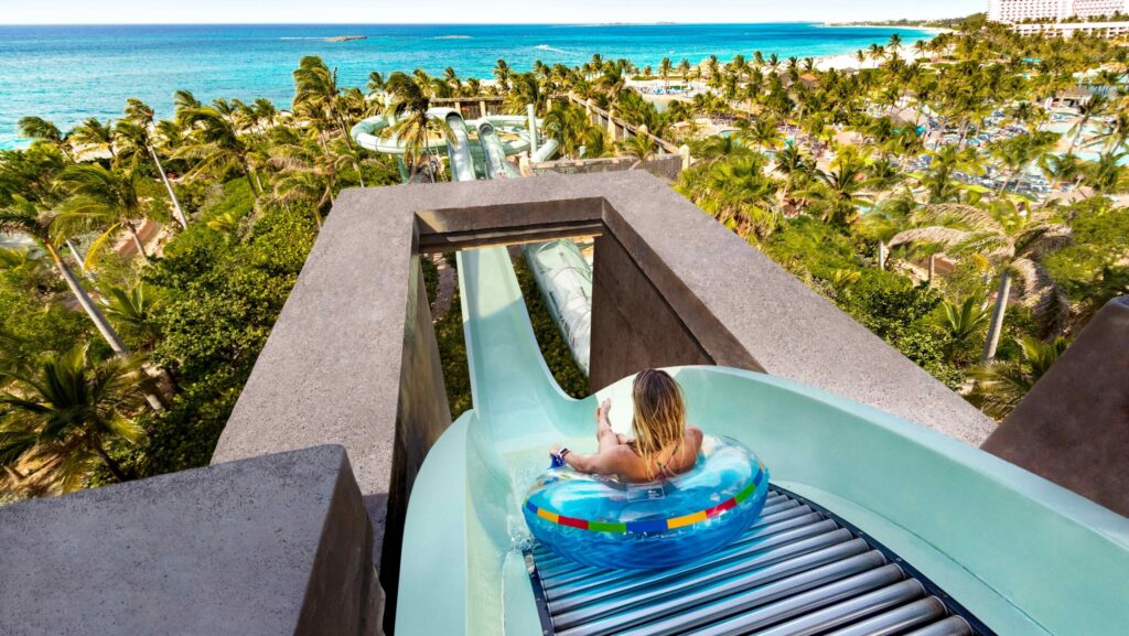 A female on an inner tube at the top of The Surge waterslide overlooking Atlantis Resort