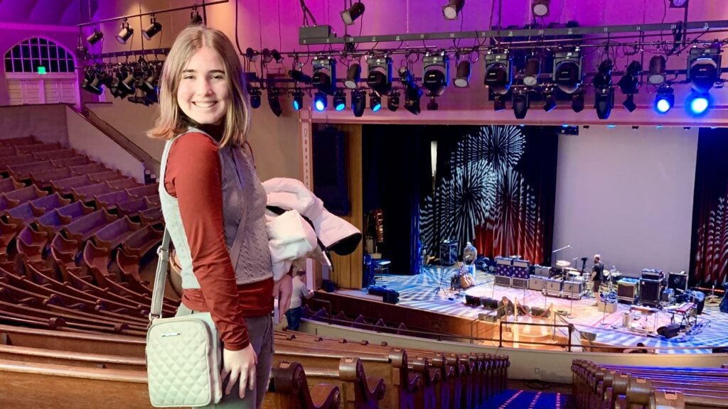 Teenager posing in a music venue in Nashville on a winter weekend trip with a parent