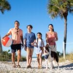 Family and dog on beach (Photo: TradeWinds Island Resort)