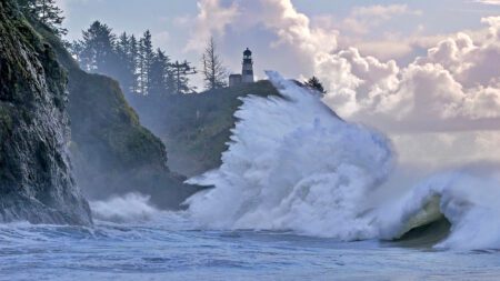 king tide crashing against the rocks below a lighthouse on Long Beach Peninsula in Washington state