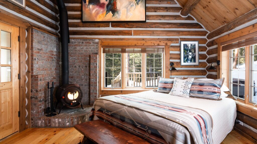 A log-cabin style guest room with a fireplace at Triple Creek Ranch