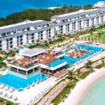 An aerial view of pools and the beach at Excellence Oyster Bay