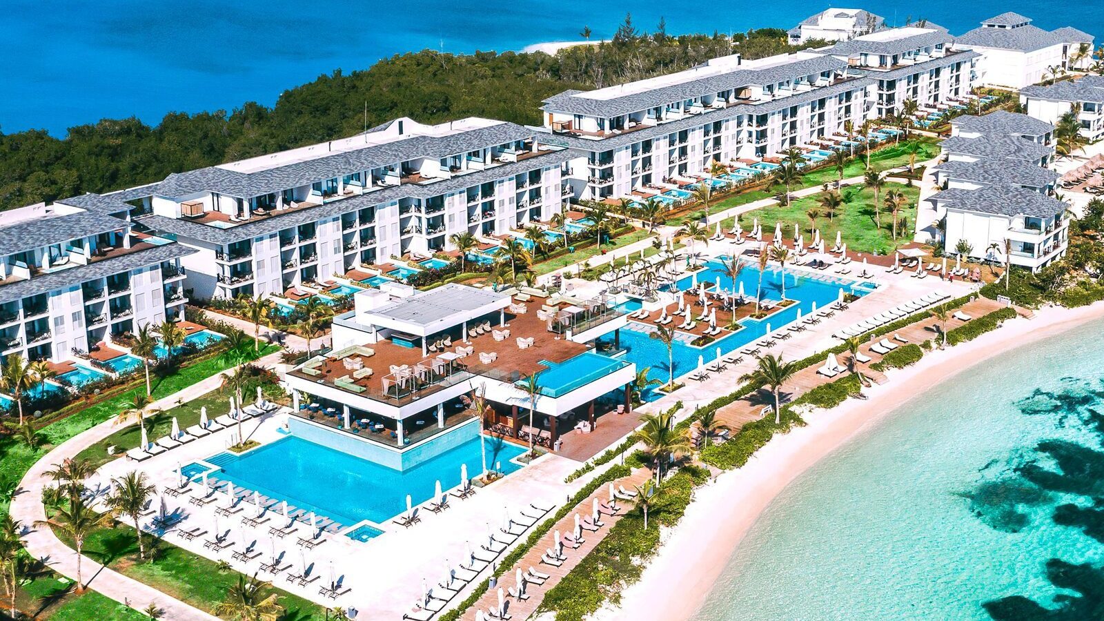 An aerial view of pools and the beach at Excellence Oyster Bay