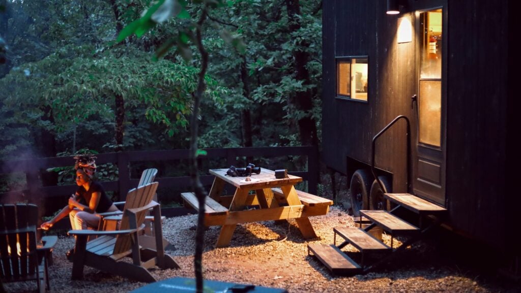 Getaway glamping with person by campfire in the evening