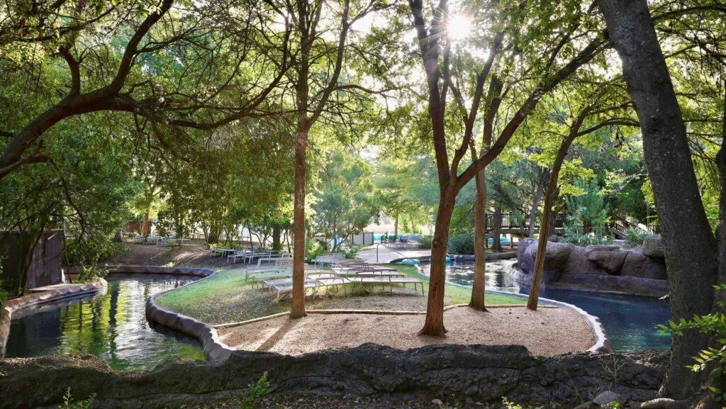 A view of the lazy river shaded by trees at Hyatt Regency Hill Country that's made to look like a Texas river.