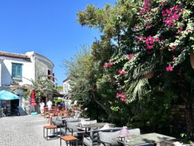 alacati street with tables and blooming vines