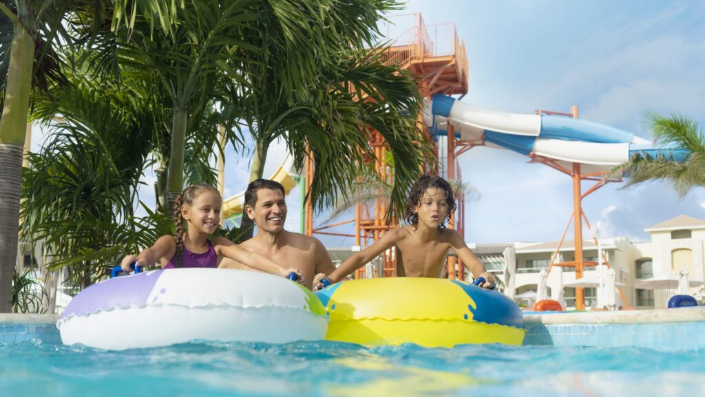 Two kids and a man in the lazy river at Moon Palce The Grand Cancun