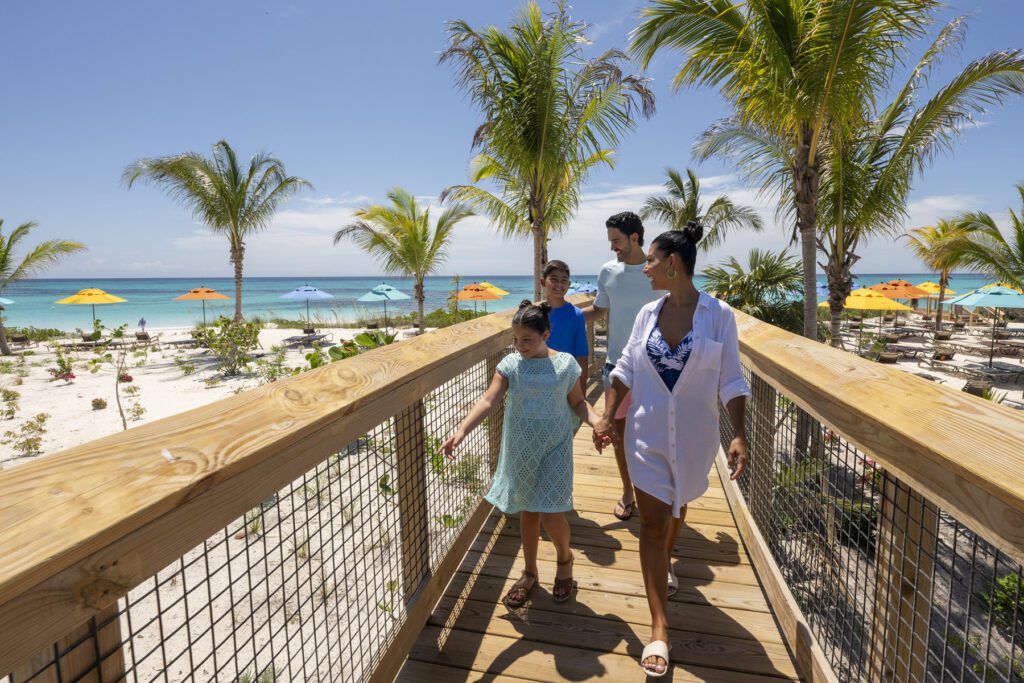 Sebuah keluarga berjalan di sepanjang jalan setapak yang ditinggikan di Disney's Lookout Cay di Lighthouse Point di pulau Eleuthera di Bahama
