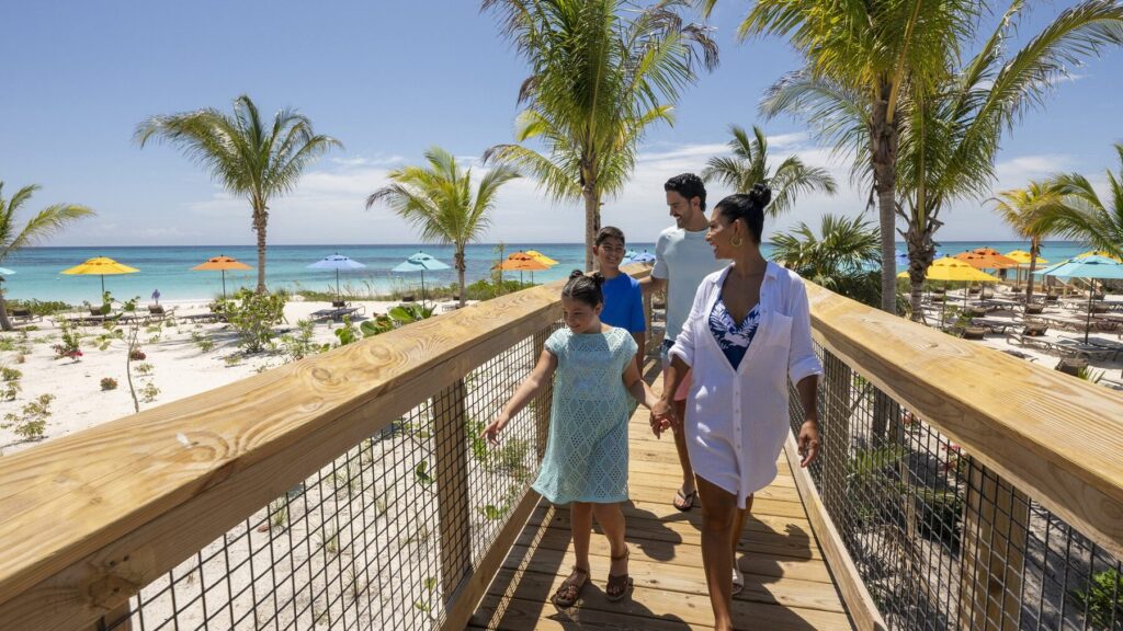 Family walking on a raised boardwalk at Disney Lookout Cay at Lighthouse Point on the island of Eleuthera in The Bahamas