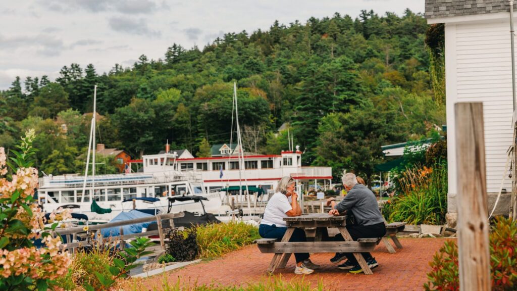 People sitting at a picnic table at Sunapee Harbor