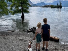 two kids and a dog look out from Isola Bella to Isola dei Pescatori on Lake Maggiore in the Italian lake district