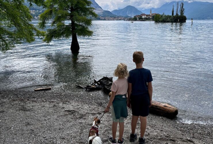 two kids and a dog look out from Isola Bella to Isola dei Pescatori on Lake Maggiore in the Italian lake district