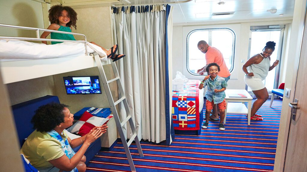 family with young kids relaxing in a Carnival Cruise Line Family Harbor Suite