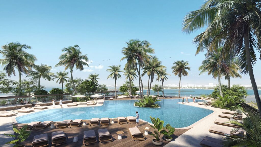 Pool on hotel top floor overlooking water and Miami skyline and surrounding by palm trees and shaded lounge chairs