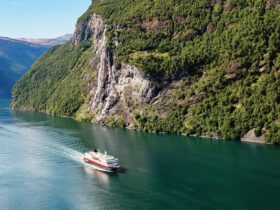 Cruise ship sailing through a mountainous village in Norway