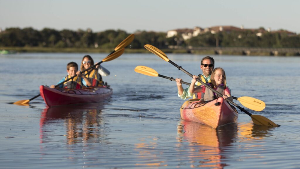 A family kayaking through the salt marshes at Sea Island