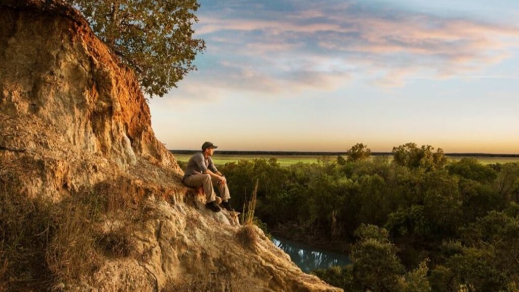 A man sitting on rocks taking in a view