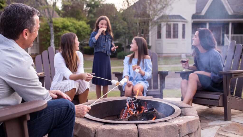 A family roasts marshmallows around a fire pit