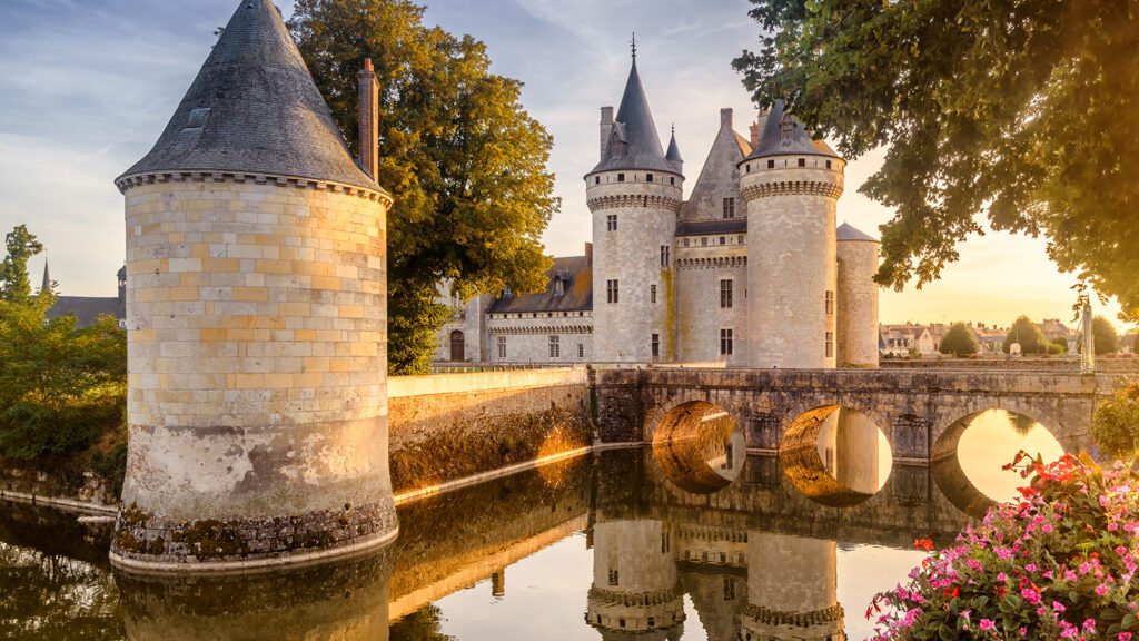 Castle and bridge along a river at sunset