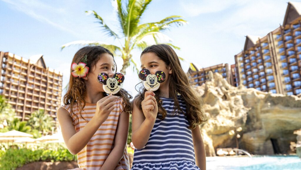 Two girls in striped dresses with Mickey ice cream bars at Aulani