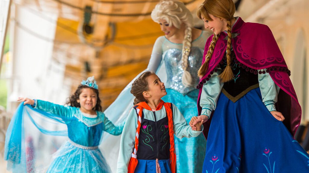 Two young girls meet actors dressed as princesses