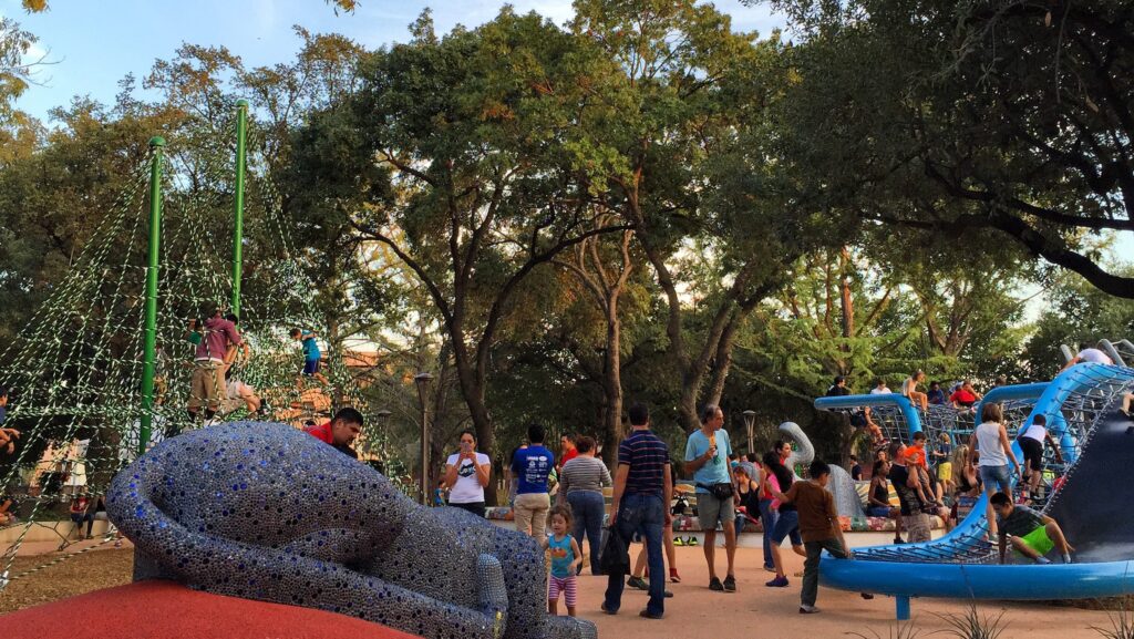 Kids and adults playing and gathering at Hemisfair park in San Antonio