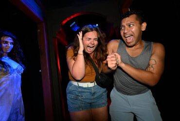 Two people going through a Halloween Horror Nights House at Universal Orlando Resort