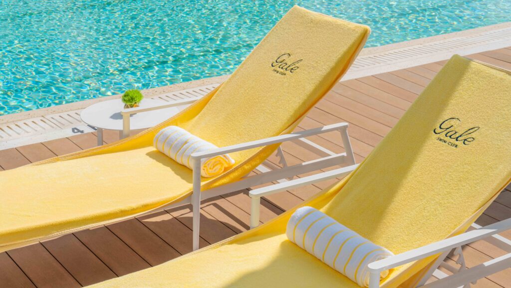 Two yellow lounge chairs by the pool at Gale Miami Hotel