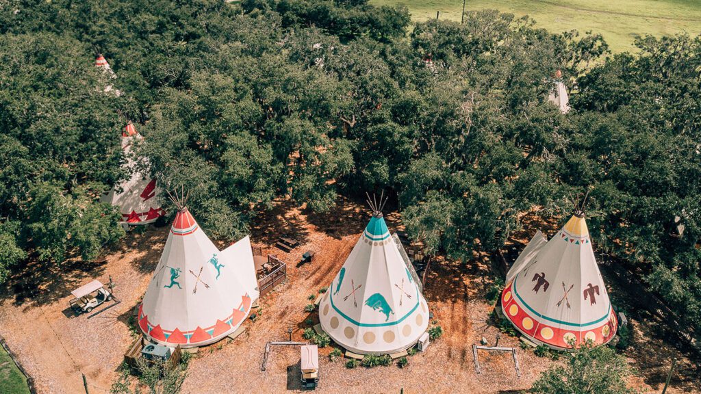 Three Teepees surrounding by dense forest