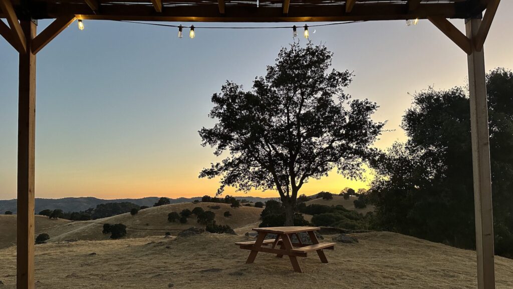 picnic table with sunset in background at Wildhaven Yosemite