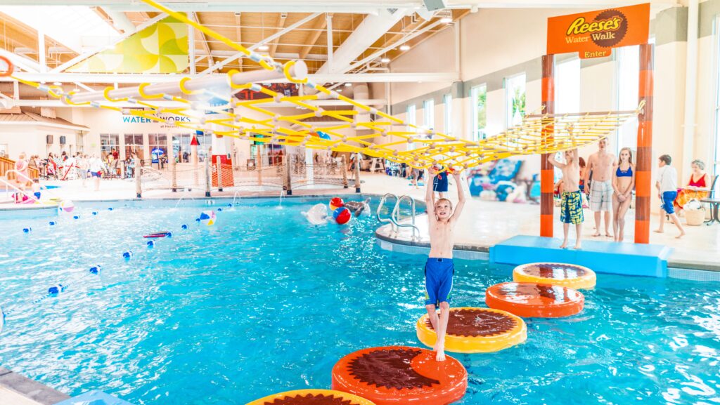 A boy crossing a floating bridge at an indoor water park