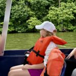 child on a Trafalgar tour of Costa Rica looking out from a seat on a boat in Tortuguero National Park