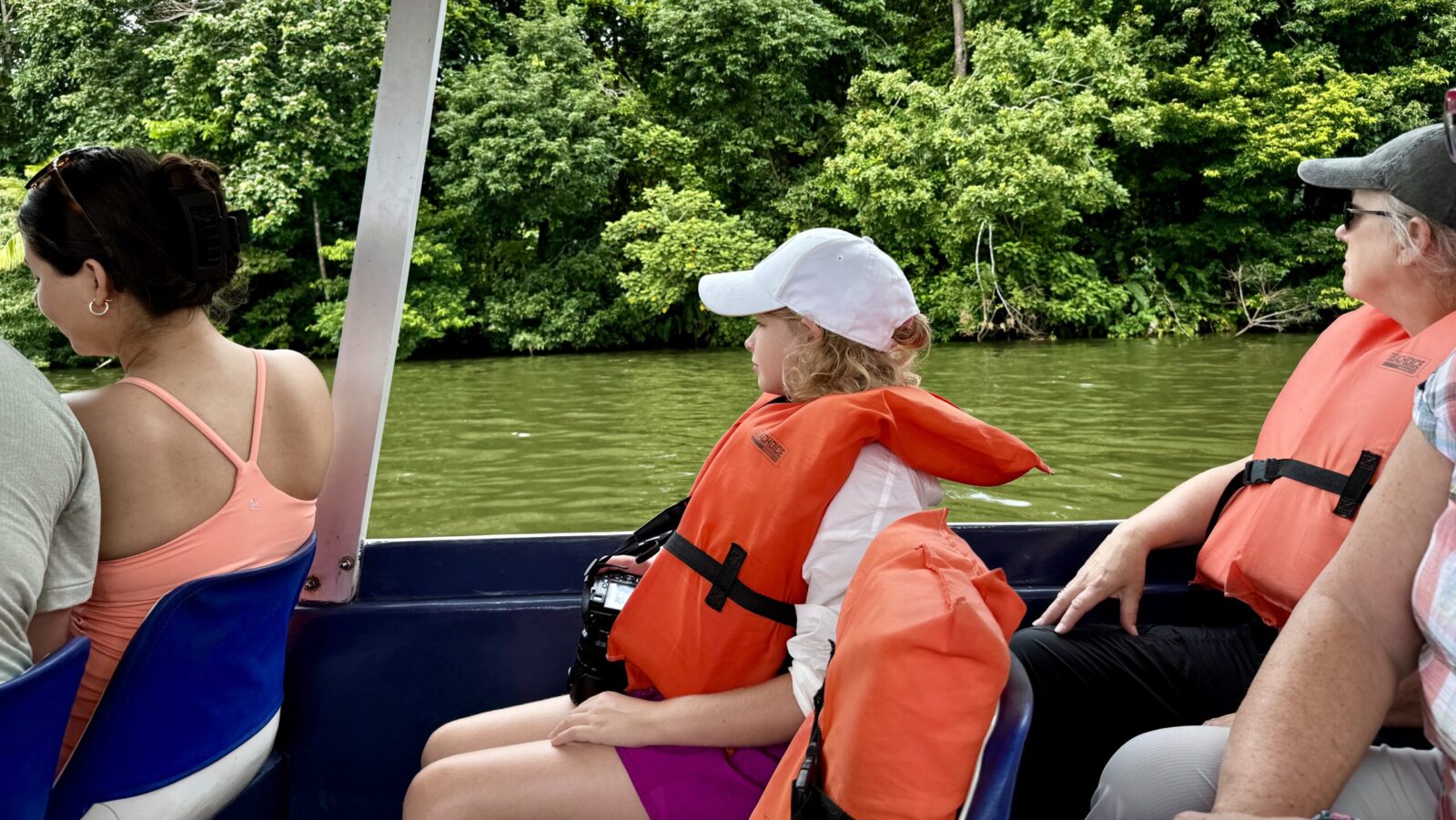 child on a Trafalgar tour of Costa Rica looking out from a seat on a boat in Tortuguero National Park