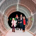 A family walking through a lighted tunnel at Calloway Resort & Gardens