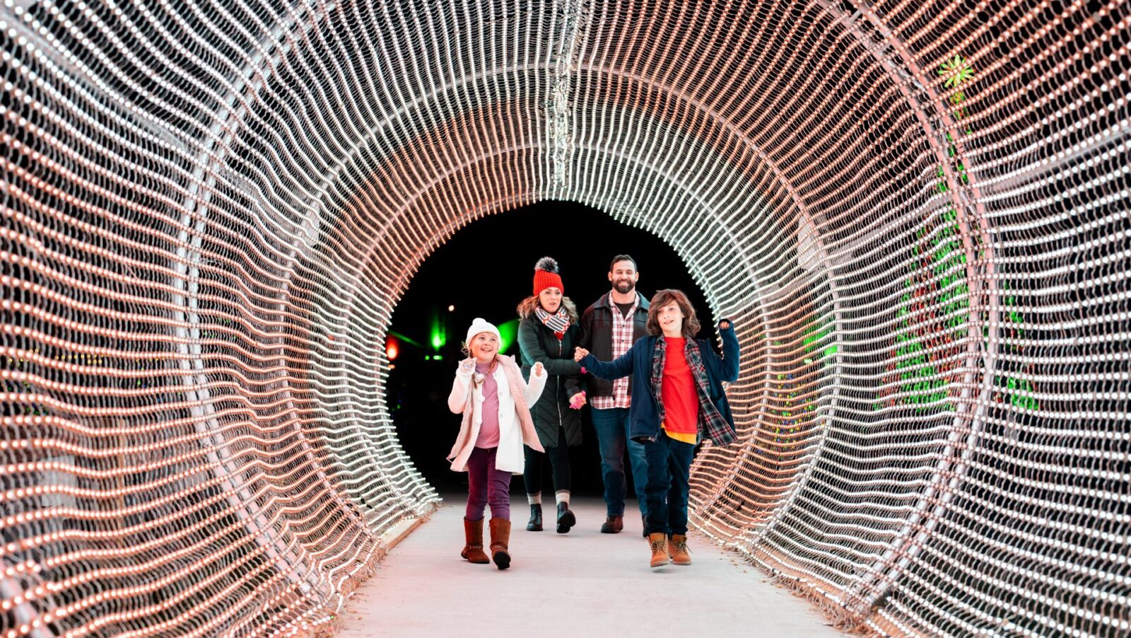 A family walking through a lighted tunnel at Calloway Resort & Gardens