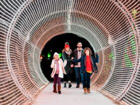 A family walking through a lighted tunnel at Calloway Resort & Gardens