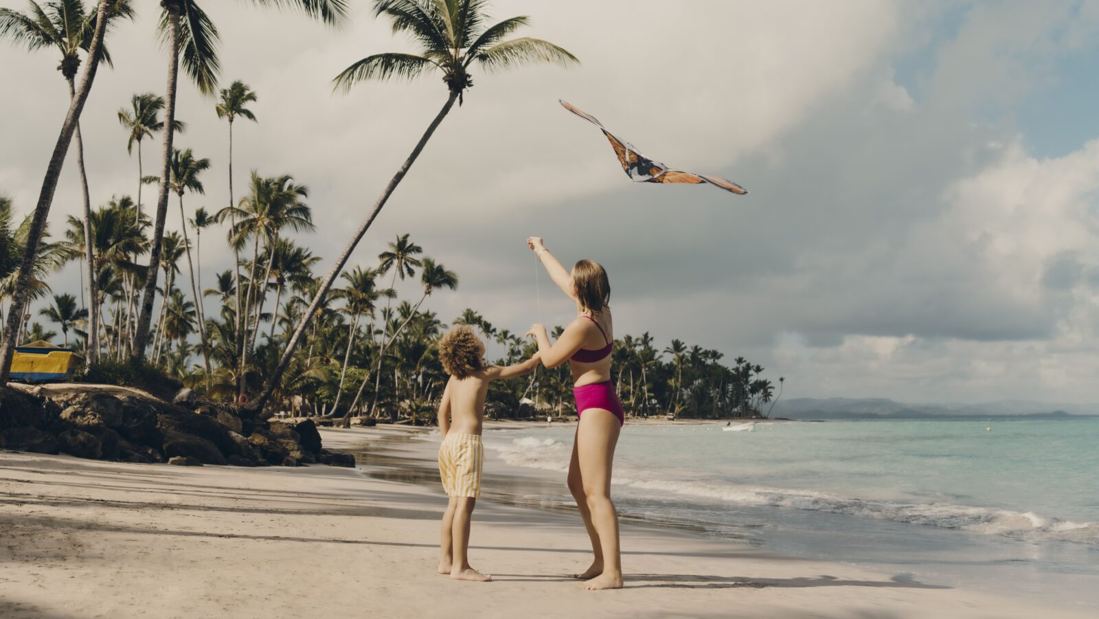 Two kids flying a kite on a beach