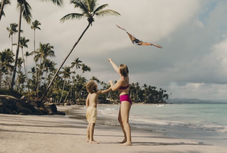 Two kids flying a kite on a beach