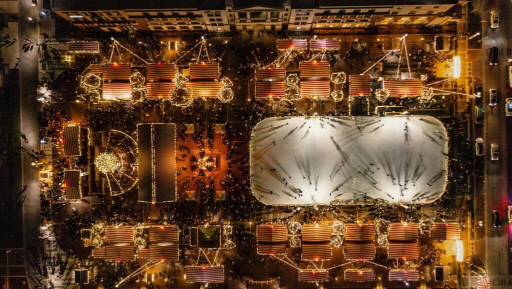 An aerial view of the Carmel Christkindlmarkt and its ice skating rink all lit up at night