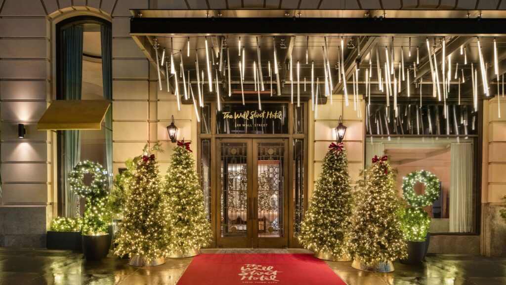 Lighted Christmas tress and other holiday decorations outside The Wall Street Hotel