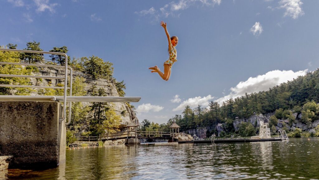 A girl jumping into the lake at Mohonk Mountain House