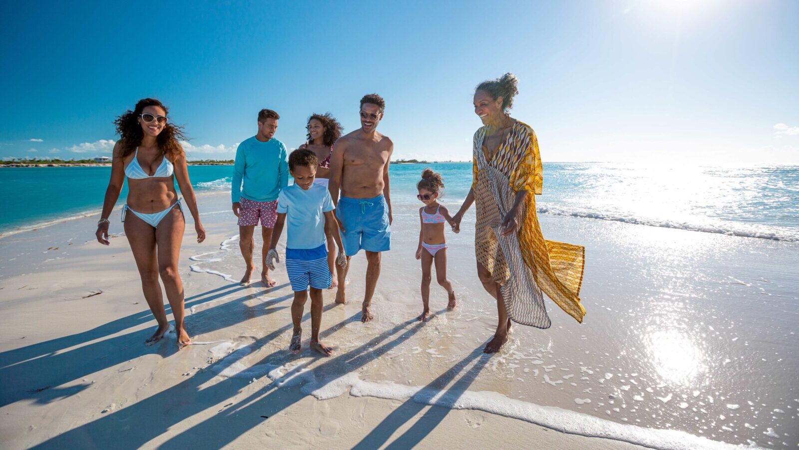 A multigenerational family walking on the beach at a Beaches Resorts property