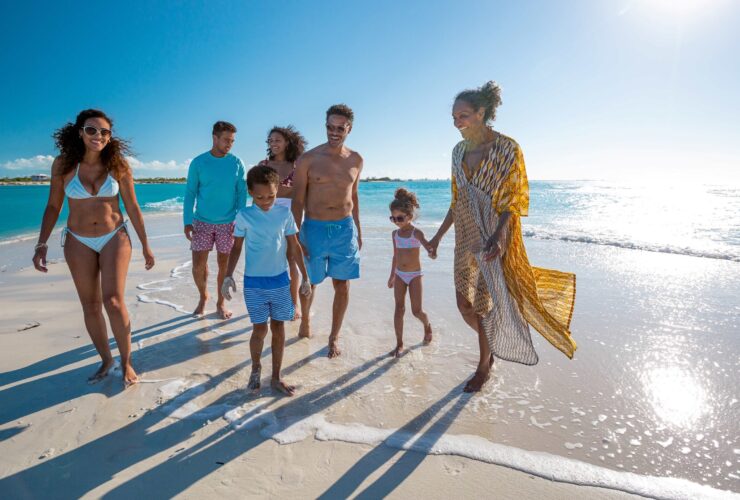 A multigenerational family walking on the beach at a Beaches Resorts property