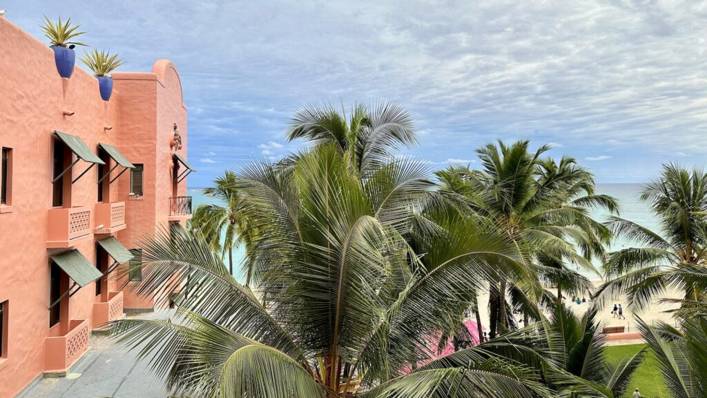 view from a room at the Royal Hawaiian out toward Waikiki Beach with palm trees