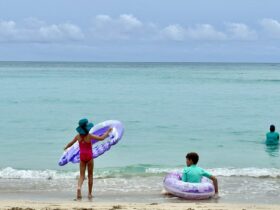 Kids playing in the calm waters at Waikiki Beach near the Royal Hawaiian