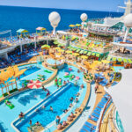 Swimming pool surrounded by many deck chairs on cruise ship