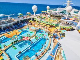 Swimming pool surrounded by many deck chairs on cruise ship