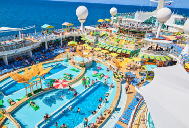 Swimming pool surrounded by many deck chairs on cruise ship